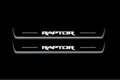 Two long door sill plates with Raptor lettering and edges illuminated in white, straight-on view on a dark background.