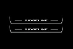 Two long door sill plates with Ridgeline lettering and edges illuminated in white, straight-on view on a dark background.