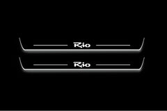 Two long door sill plates with Rio in script lettering and edges illuminated in white, straight-on view on a dark background.