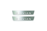 Two short silver-finished door sill plates with Rivian with diamond emblems lettering on a light background, straight-on view.