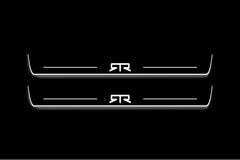Two long door sill plates with RTR emblems lettering and edges illuminated in white, straight-on view on a dark background.