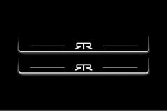 Two long door sill plates with RTR emblem lettering and edges illuminated in white, straight-on view on a dark background.