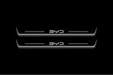 Two long door sill plates with BYD lettering and edges illuminated in white, straight-on view on a dark background.