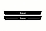 Catalogue illustration of two front black Matte PRO LED door sill plates with illuminated Skoda lettering for Škoda Enyaq; dimensions are selected during manufacture.