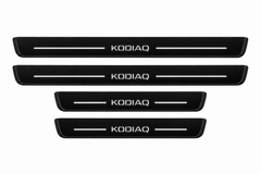 Catalogue demonstration of two long front and two short rear black Matte PRO sill plates with illuminated KODIAQ lettering and straight top lines; dark side edges remain unlit. Dimensions selected for Škoda Kodiaq NS7 during manufacture.