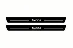 Catalogue illustration of two front black Matte PRO LED door sill plates with illuminated Skoda lettering for Skoda Octavia (A7) III; dimensions are selected during manufacture.