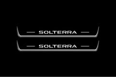 Two long door sill plates with Solterra lettering and edges illuminated in white, straight-on view on a dark background.