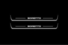 Two long door sill plates with Sorento lettering and edges illuminated in white, straight-on view on a dark background.