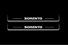 Two long door sill plates with Sorento lettering and edges illuminated in white, straight-on view on a dark background.