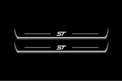 Two long door sill plates with ST lettering and edges illuminated in white, straight-on view on a dark background.