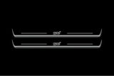 Two long door sill plates with STI lettering and edges illuminated in white, straight-on view on a dark background.