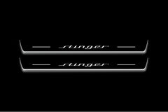 Two long door sill plates with Stinger lettering and edges illuminated in white, straight-on view on a dark background.