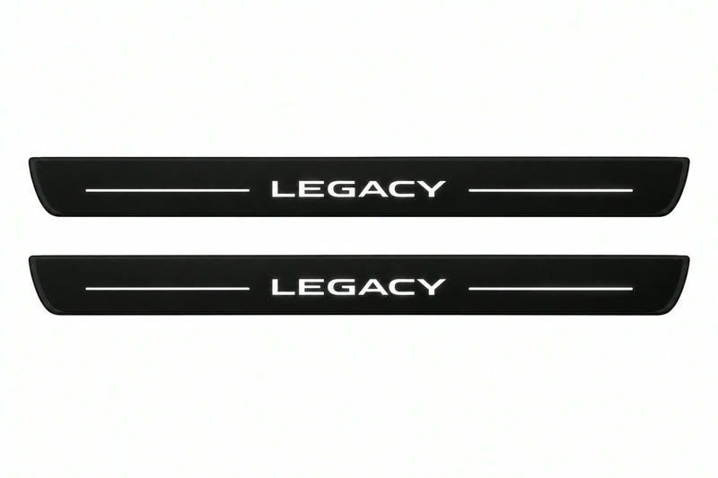 Catalogue illustration of two front black Matte PRO LED door sill plates with illuminated Legacy lettering for Subaru Legacy V; dimensions are selected during manufacture.