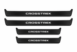 Catalogue illustration of two long black Matte PRO front sill plates and two shorter rear plates with CROSSTREK lettering illuminated on the top. Side edges unlit; vehicle-specific dimensions are not depicted. FRONT option includes front plates only.