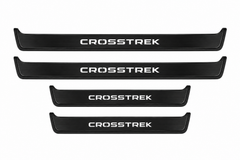 Catalogue illustration of two long black Matte PRO front sill plates and two shorter rear plates with CROSSTREK lettering illuminated on the top. Side edges unlit; vehicle-specific dimensions are not depicted. FRONT option includes front plates only.