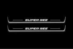 Two long door sill plates with Super Bee lettering and edges illuminated in white, straight-on view on a dark background.
