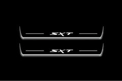 Two long door sill plates with SXT lettering and edges illuminated in white, straight-on view on a dark background.