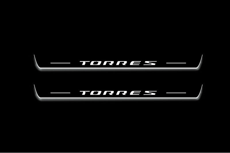 Two long door sill plates with Torres lettering and edges illuminated in white, straight-on view on a dark background.