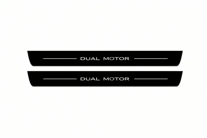 Catalogue illustration of two front black Matte PRO LED door sill plates with illuminated Dual Motor lettering for Tesla Model 3; dimensions are selected during manufacture.