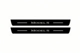 Catalogue illustration of two front black Matte PRO LED door sill plates with illuminated Model S lettering for Tesla Model S; dimensions are selected during manufacture.