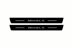 Catalogue illustration of two front black Matte PRO LED door sill plates with illuminated Model S lettering for Tesla Model S; dimensions are selected during manufacture.