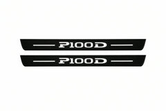 Catalogue illustration of two front black Matte PRO LED door sill plates with illuminated P100D lettering for Tesla Model S; dimensions are selected during manufacture.