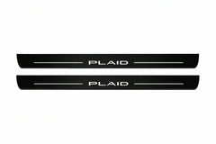 Catalogue illustration of two front black Matte PRO LED door sill plates with illuminated PLAID lettering for Tesla Model S; dimensions are selected during manufacture.