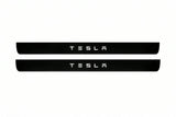 Catalogue illustration of two front black Matte PRO LED door sill plates with illuminated TESLA lettering for Tesla Model S; dimensions are selected during manufacture.