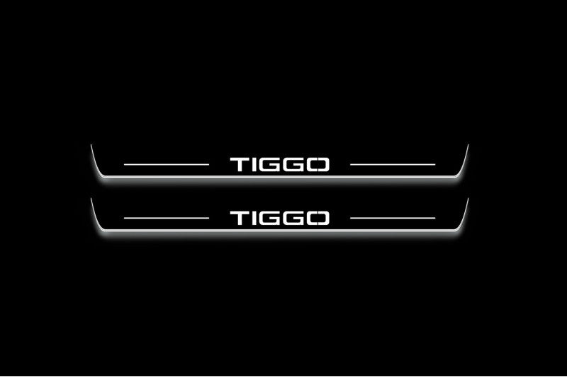 Two long door sill plates with Tiggo lettering and edges illuminated in white, straight-on view on a dark background.