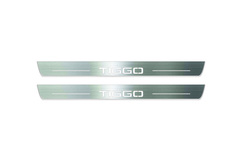 Two long silver-finished door sill plates with Tiggo lettering on a light background, straight-on view.