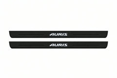 Catalogue illustration of two front black Matte PRO LED door sill plates with illuminated Auris lettering for Toyota Auris II E180; dimensions are selected during manufacture.