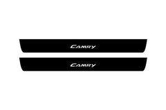 Catalog illustration of two black front door sill plates with Camry lettering.