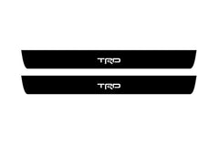Catalog illustration of two black front door sill plates with TRD lettering.