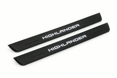 Catalogue illustration of two front black Matte PRO LED door sill plates with illuminated Highlander lettering for Toyota Highlander XU70; dimensions are selected during manufacture.