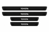 Catalogue illustration of two long front and two short rear black Matte PRO sill plates with illuminated TOYOTA lettering only on top, unlit horizontal grooves and opaque side edges. Actual dimensions selected for Land Cruiser 250 J250 during manufacture.