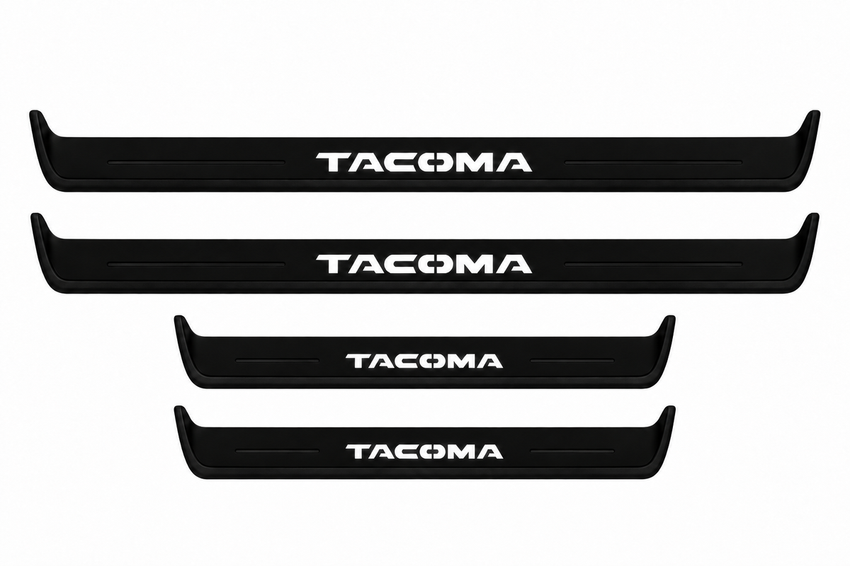 Catalogue illustration of two long black Matte PRO front sill plates and two shorter rear plates with TACOMA lettering illuminated on top. Side edges unlit; vehicle-specific dimensions are not depicted. FRONT option includes front plates only.