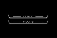 Two long door sill plates with Trafic lettering and edges illuminated in white, straight-on view on a dark background.