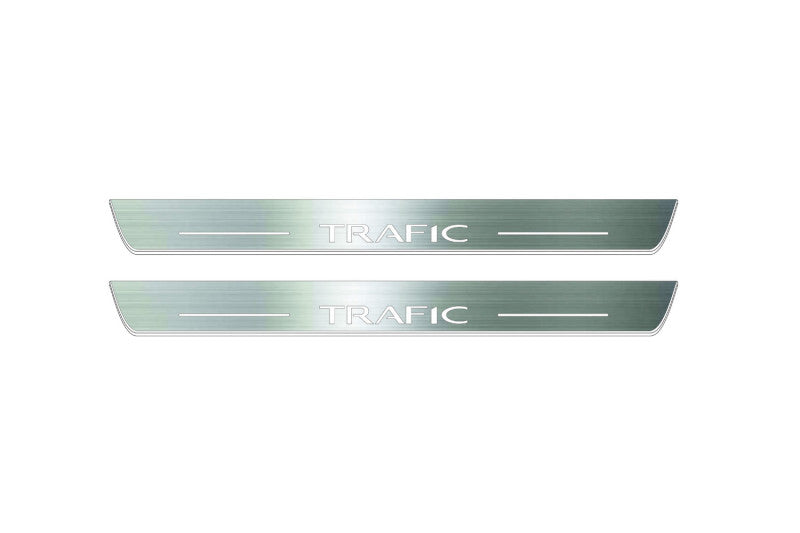 Two long silver-finished door sill plates with Trafic lettering on a light background, straight-on view.