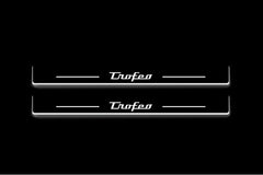 Two long door sill plates with Trofeo lettering and edges illuminated in white, straight-on view on a dark background.