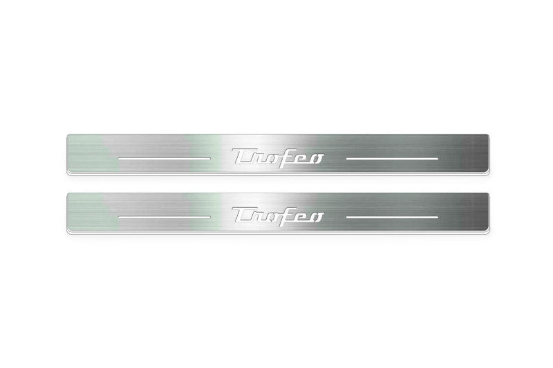 Two long silver-finished door sill plates with Trofeo lettering on a light background, straight-on view.