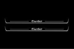 Two long door sill plates with Turbo lettering and edges illuminated in white, straight-on view on a dark background.