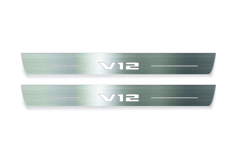 Two long silver-finished door sill plates with V12 lettering on a light background, straight-on view.