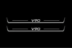 Two long door sill plates with V90 lettering and edges illuminated in white, straight-on view on a dark background.