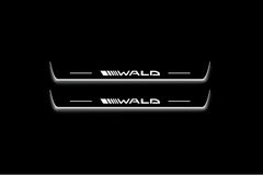 Two long door sill plates with Wald lettering and edges illuminated in white, straight-on view on a dark background.