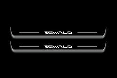 Two long door sill plates with Wald lettering and edges illuminated in white, straight-on view on a dark background.