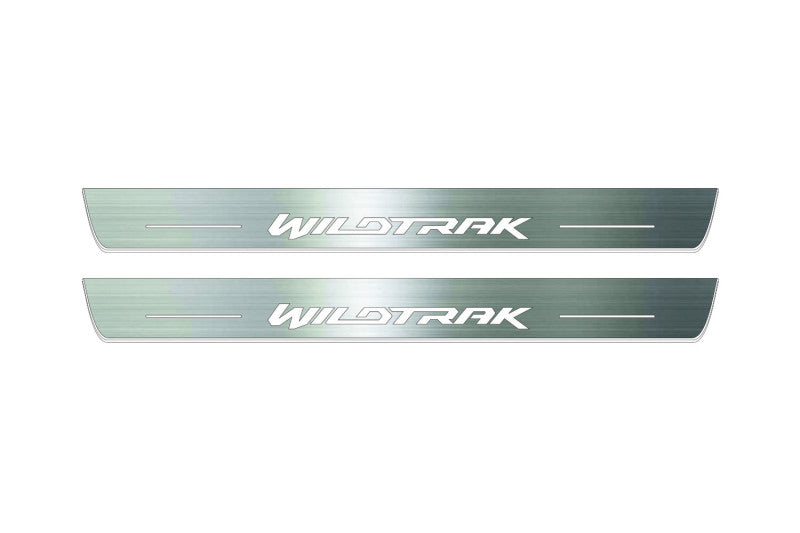 Two long silver-finished door sill plates with Wildtrak lettering on a light background, straight-on view.