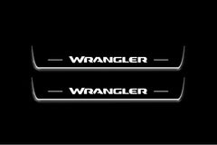 Two long door sill plates with Wrangler lettering and edges illuminated in white, straight-on view on a dark background.