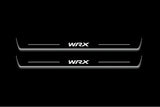 Two long door sill plates with WRX lettering and edges illuminated in white, straight-on view on a dark background.