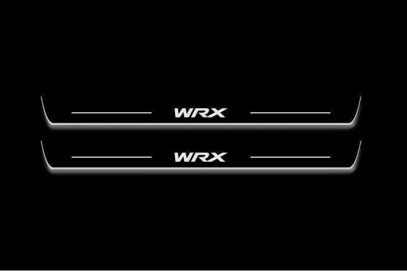Two long door sill plates with WRX lettering and edges illuminated in white, straight-on view on a dark background.