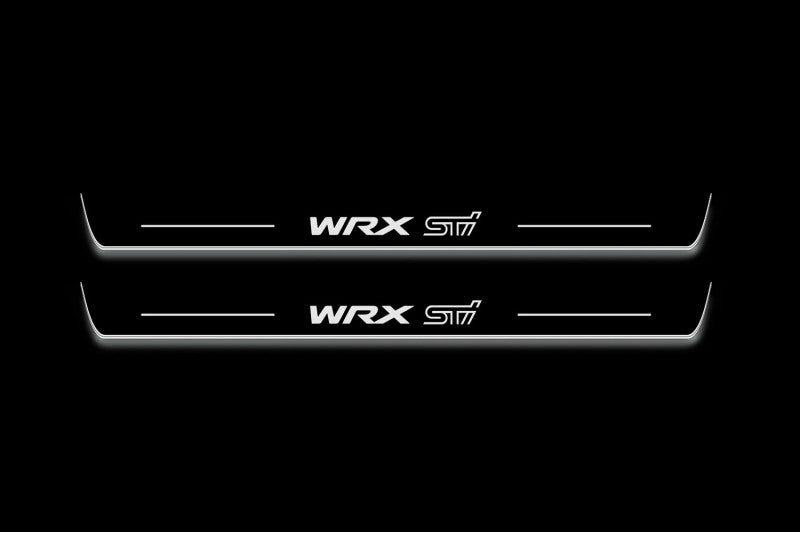 Two long door sill plates with WRX STI lettering and edges illuminated in white, straight-on view on a dark background.